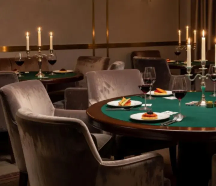 Gyertyafényes lounge tér pókerasztalokkal és boros poharakkal a Programter99-ben.